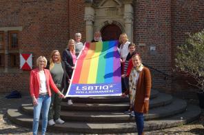 Mitarbeiterinnen der Arbeitsgemeinschaft der Gleichstellungsbeauftragten im Kreis Kleve mit einer Regenbogenflagge