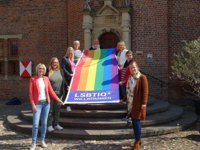 Mitarbeiterinnen der Arbeitsgemeinschaft der Gleichstellungsbeauftragten im Kreis Kleve mit einer Regenbogenflagge